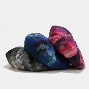 Three retro plaid beret hats in grey, blue, and pink colors showing thick woolen texture