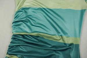 Detailed close-up of side drawstring ruching on green and cyan striped bodycon dress