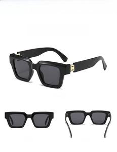 Macro view of square sunglasses with black frame and golden metal hinge details