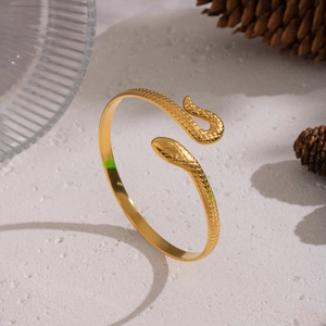 Gros plan détaillé d'un bracelet serpent doré avec des textures d'écailles sur pierre
