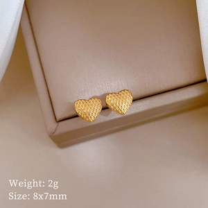 Macro shot of 8x7mm golden heart studs with quilted texture and 2g weight details