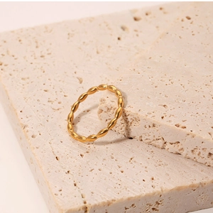 Macro detail of gold textured stackable ring on minimalist travertine stones