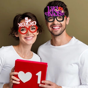 Detail of glittery XOXO and KISS party glasses with red heart gift box decorations