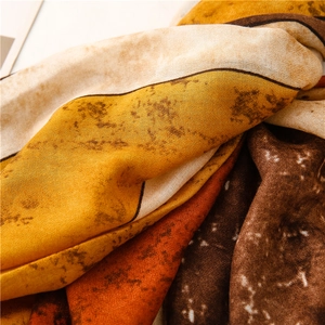 Detailed close-up of ink-wash style cotton linen scarf with abstract yellow patterns