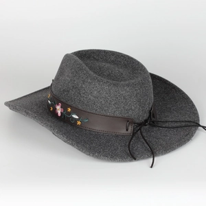 Close-up of dark gray wool felt fedora with floral embroidery on brown leather band