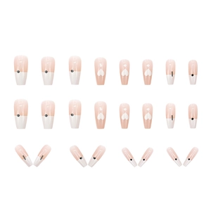 Long coffin press-on nails in light pink with French tips, black dots, and heart patterns