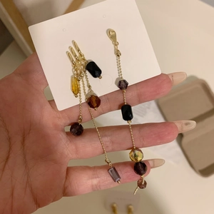 Handheld view of vintage long beaded dangle earrings with multi-color faceted crystals