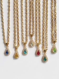 Detailed macro view of pear-cut colorful zircon necklaces with 18k gold plating