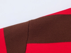 Gros plan du tricot avec rayures rouges et brunes et coutures détaillées à l'épaule