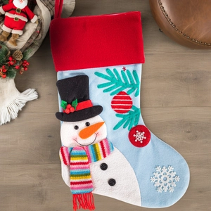 Close-up of a Christmas stocking with 3D snowman, snowflakes and red pom-poms on wood