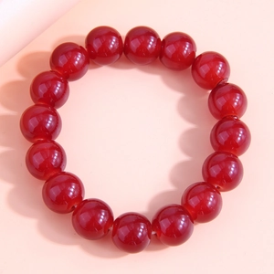 Detailed view of glossy red glass beads with smooth texture on a minimalist bracelet