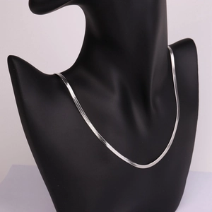 Detail of a sleek silver flat snake chain necklace with high-polish mirror finish