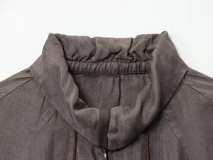 Detail shot of a dark grey bomber jacket collar with premium fabric texture and elastic ribbing