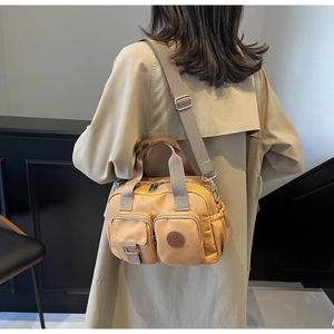 Rückansicht eines Modells mit brauner Nylon-Umhängetasche mit verstellbarem Gurt und Taschen