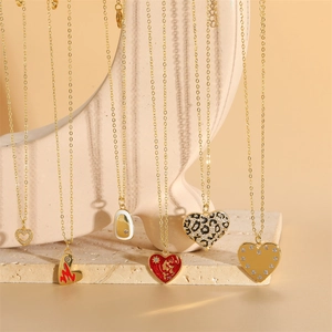Gold heart pendant necklace set with leopard print and red enamel on art mannequin