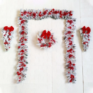 Christmas garland set with flocked pine branches, red bows and berries for festive decor