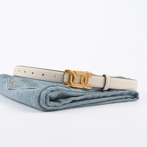 Ceinture pour femme en cuir véritable avec boucle dorée double anneau sur un jean bleu