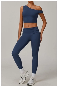 Détail de l'ensemble de yoga bleu foncé avec haut asymétrique à une épaule et legging froncé