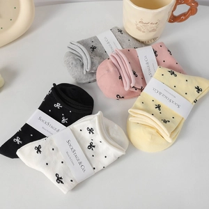 Detailed set of five cotton socks in pastel colors with small black bows and polka dots