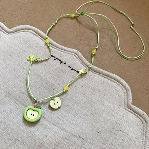 Collier avec pendentif pomme verte et étoile jaune sur cordon tressé et lin chic