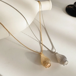 Detailed macro view showing gold and silver teardrop pendants with woven mesh texture and bead chains
