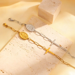 Detail of vintage religious paperclip bracelets with Mary medal and cross in gold and silver