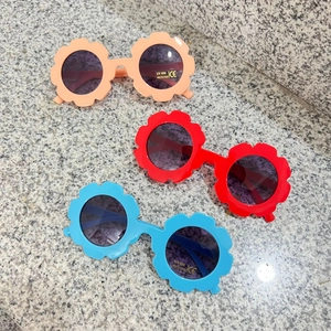 Detailed view of flower-shaped children's sunglasses with UV400 protection stickers