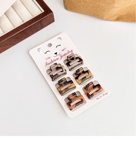 Detail shot of six mini leopard print hair claws on a cat-themed display card