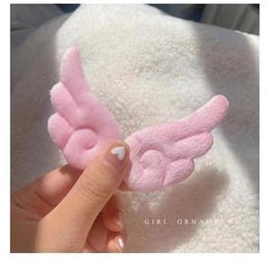 Detail einer weichen rosa Plüsch-Engelsflügel-Haarklammer mit dekorativer Spiralsteppung