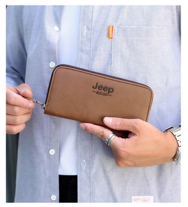 Macro shot of brown leather long wallet featuring textured grain and a secure zipper