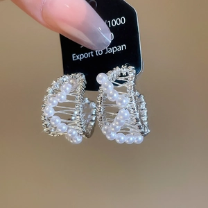 Detailed macro view of S925 silver woven earrings with elegant white pearl accents