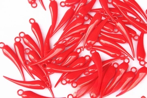 Close-up of bright red chili-shaped charms with glossy finish and metal rings for DIY crafts