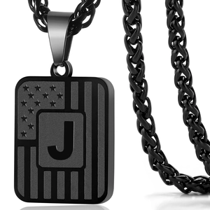 Close-up of gun black dog tag necklace with American flag and letter J engraving