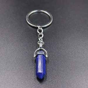 Macro view of blue hexagonal crystal stone pendant and silver keychain connector