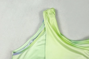 Detail of the crew neck stitching and gathered pleats on the light green dress fabric