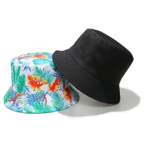 Detail view of two bucket hats showing solid black and tropical palm leaf print designs