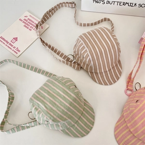 Detailed view of stripe canvas baseball cap shaped crossbody bags with metal ring decor