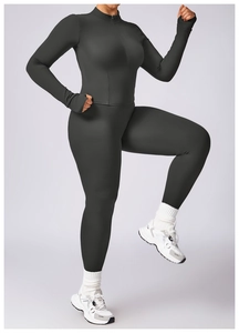 Detail of dark gray high-waisted yoga set featuring long sleeve zip-up top with thumbholes
