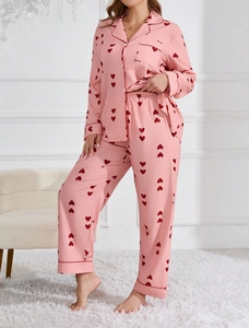 Detail view of pink pajamas set with red heart pattern and contrasting trim on cuffs
