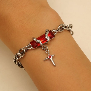 Gothic silver bracelet featuring a rectangular red gemstone and a small cross charm