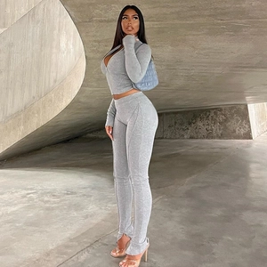 Detail of grey yoga set showing zipper crop top and high waist split hem leggings