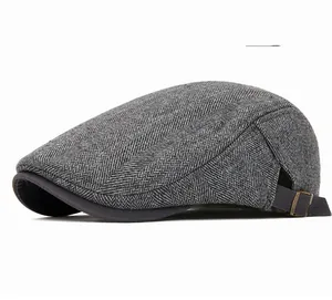 Detail of grey herringbone wool fabric and bronze metal buckle on the flat cap
