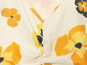 Detail of V-neckline and rib-knit fabric texture with yellow sunflower floral print