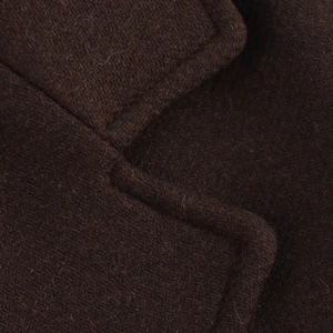 Detailed close-up of dark brown wool blend coat showing high-quality stitching and texture