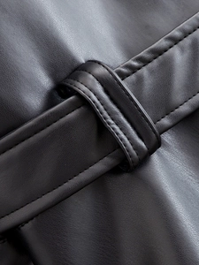 Detail shot of black leather jacket belt loops showing premium texture and stitching