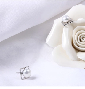 Macro shot of silver square frame earrings with elegant white freshwater pearl inlay