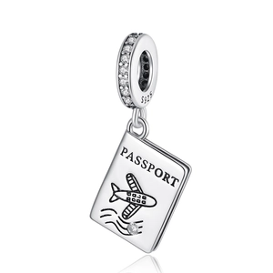 Macro detail of silver S925 passport charm with cubic zirconia and airplane engraving