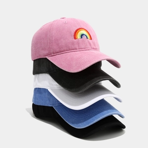 Vertical stack of retro washed cotton baseball caps in five colors with rainbow embroidery