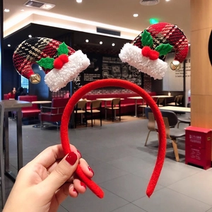 Detail of a red velvet Christmas headband featuring plaid hats with bells and berries