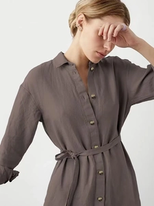 Dettaglio dell'abbottonatura singola e trama del tessuto su un abito a camicia taupe